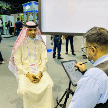 Visitor getting a caricature drawn at verloop's stall at GITEX 2020
